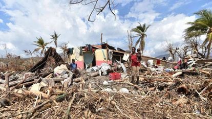 Uma mulher, na segunda-feira em frente à sua casa destruída no Haiti.