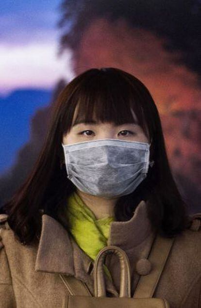 Mulher chinesa, com uma máscara para se proteger do ar poluído, no último 20 de novembro em Pequim.