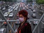 Una mujer, protegida con mascarilla, cruza por un paso elevado de Wuhan el pasado 14 de mayo.