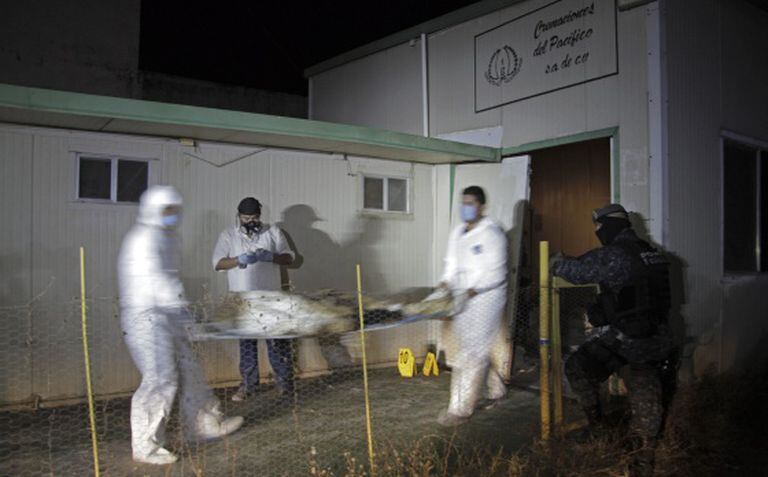 Médicos forenses levam os cadáveres encontrados em um crematório de Acapulco.
