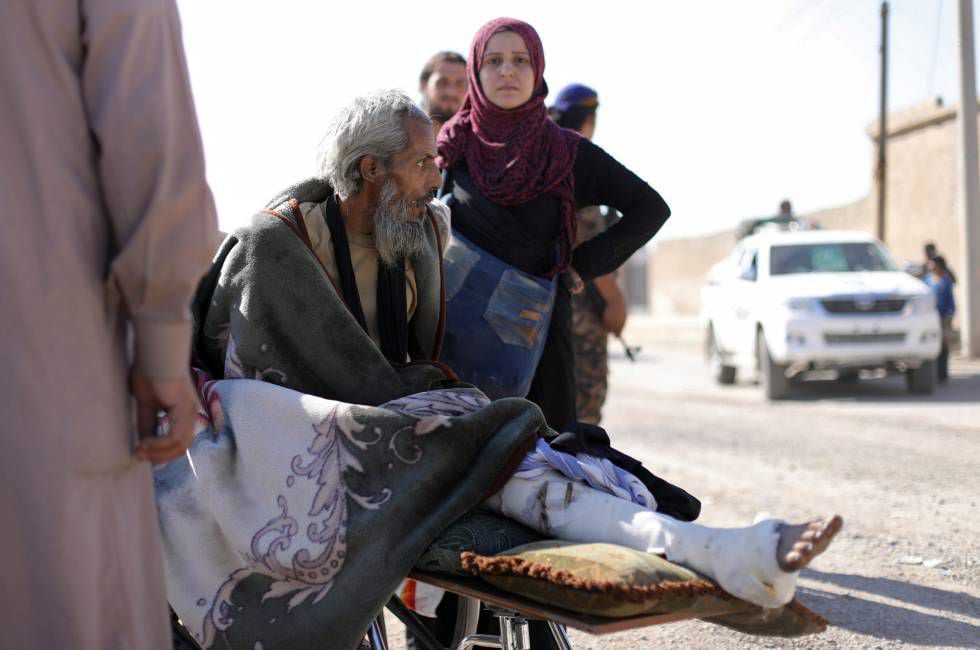 Um homem ferido em uma maca foge de Raqqa nesta terça-feira.