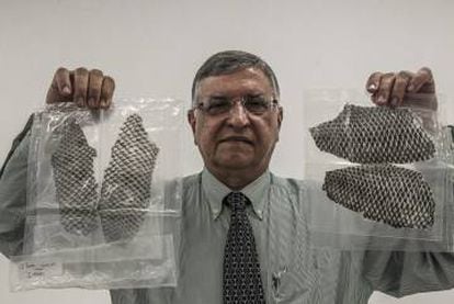 O professor Odorico Moraes segura duas embalagens com peles de tilápia prontas para o uso.