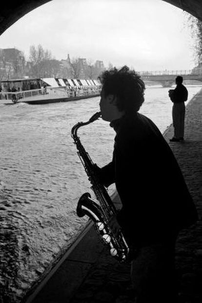 Um músico às margens do rio Sena, em Paris.
