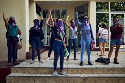 Mulheres participam de um protesto feminista na cidade de Manágua, rodeadas por um cerco policial.