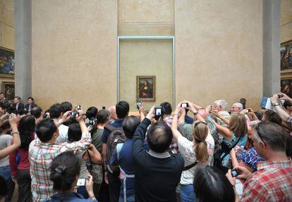 Turistas fotografam a Monalisa.