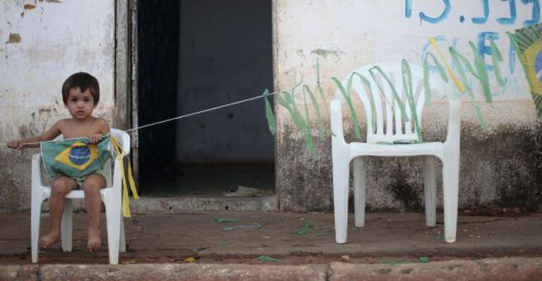 Criança brinca com bandeira brasileira em São Francisco do Brejão, no Maranhão.