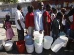 Um grupo de haitianos vítimas do terremoto faz fila para pegar água no bairro marginal de Citei du Soleil, em Porto Príncipe (22/01/2010).