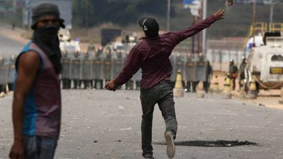 Venezuelanos em solo brasileiro atiram pedras contra soldados da Guarda Nacional Bolivariana