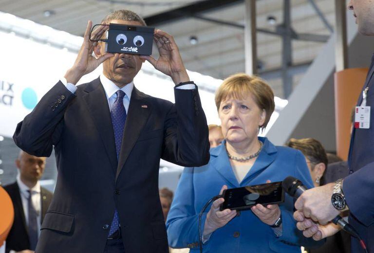 Barack Obama testa um gadget na presença de Angela Merkel durante sua visita a Hannover.