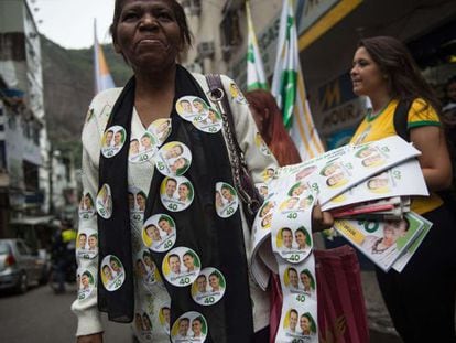 Uma mulher distribui adesivos a favor da candidatura de Marina Silva na favela da Rocinha, no Rio de Janeiro.
