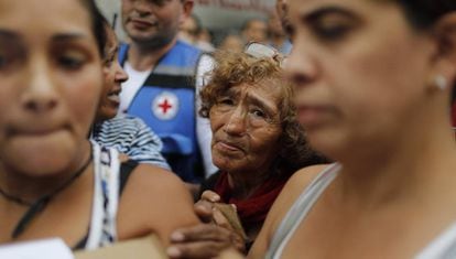 Venezuelanos esperam para receber água filtrada e medicamentos distribuídos pela Cruz Vermelha em Caracas. 
