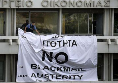 Seguran&ccedil;a tira faixa em protesto contra a austeridade, em Atenas. 