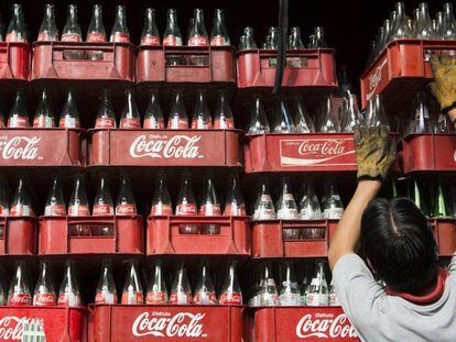 Funcionária empilha caixas de Coca-Cola na Cidade do México, em 2013