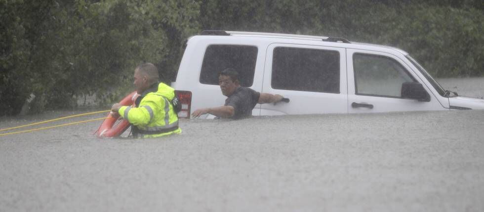 Homem é resgatado de seu carro em Houston, no domingo.