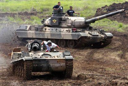 Carro de combate AMX-30 do Exército venezuelano durante manobras; ao fundo, em uma imagem de arquivo.