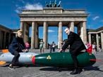 Two activists dressed up as US President Trump and Russian President Putin ride two atomic bomb models during a protest for a world without nuclear weapons in front of the Brandenburg Gate in Berlin, Germany, July 30, 2020. Several peace and disarmament organizations as well as environmental protection groups demonstrated on the Pariser Platz for a nuclear weapons-free world before the start of negotiations between the USA and Russia on further action in nuclear arms control. (Fabian Sommer/dpa via AP)
