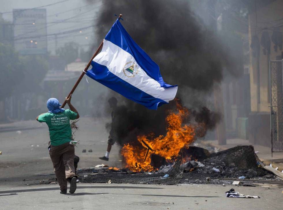 Um jovem corre com uma bandeira em Masaya (Nicarágua) durante um protesto em 2018.