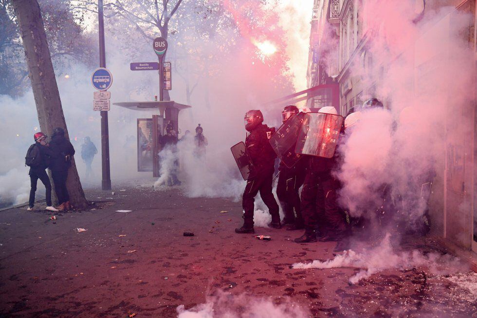 Agentes antidistúrbios em confronto com várias pessoas em uma rua do centro da capital francesa.