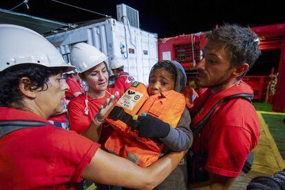 Trabalhadores de Save the Children ajudam uma criança que saiu da costa da Líbia em direção à Europa.
