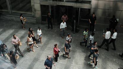Várias pessoas passam em frente à sede do banco Goldman Sachs, em Nova York.