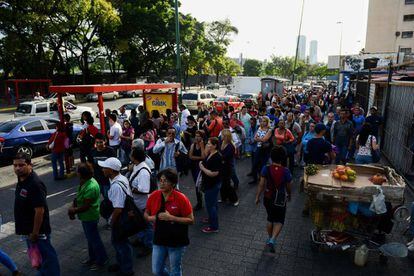 Um grupo de pessoas espera o ônibus em Caracas.
