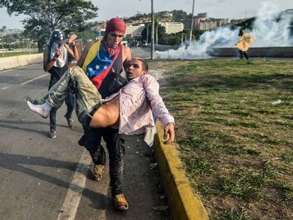 Manifestante ferido é levado durante protesto em Caracas, em maio de 2017.