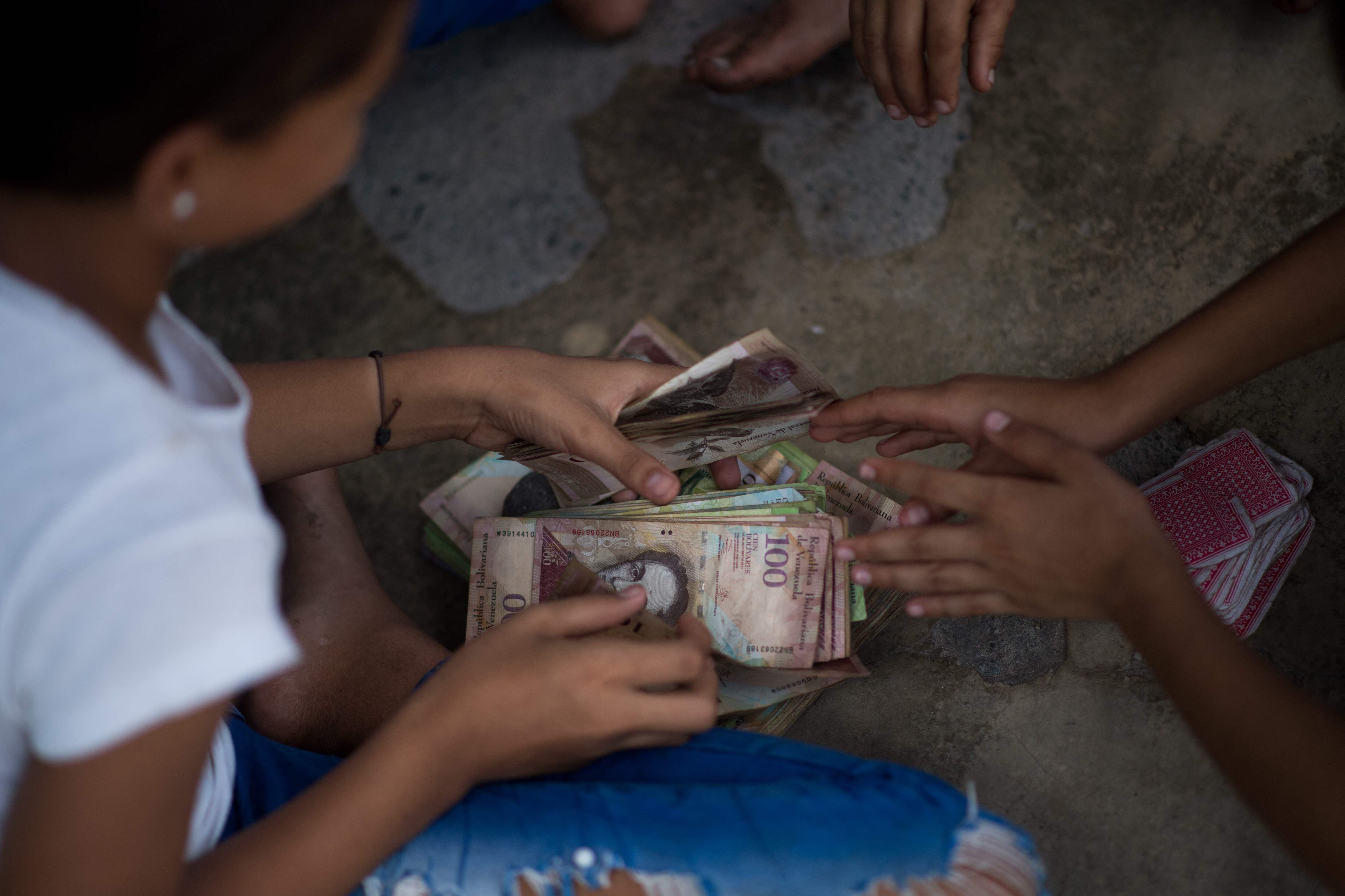 Crianças brincam com notas de bolívar não utilizadas na Venezuela em 9 de setembro.