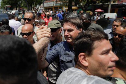 Sem máscara, Bolsonaro cumprimenta eleitores no Rio de Janeiro, ao votar neste domingo. 