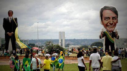Seguidores do presidente Jair Bolsonaro caminham na frente de um boneco gigante com sua figura em Brasília.