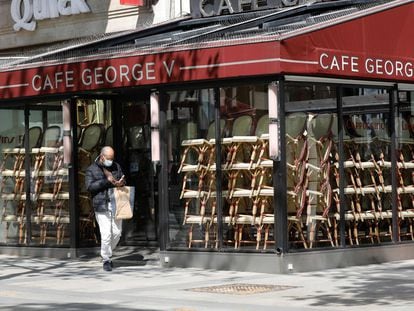 Um homem passa diante de um café fechado em Paris.