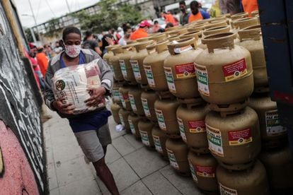 Homem carrega um pacote de alimentos que foi doado por um grupo de pessoas em uma campanha promovida por uma federação de trabalhadores no Rio de Janeiro, que vendeu gás pela metade do preço.