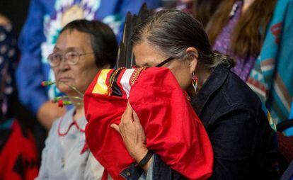 Idosa indígena canadense segura uma cópia do relatório final sobre o genocídio sofrido por seu povo, no dia 3 de junho, no Quebec.