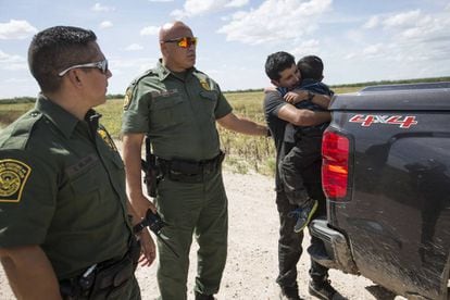 Imigrante abraça o filho no momento de ser preso pela Patrulha da Fronteira em Roma, Texas.