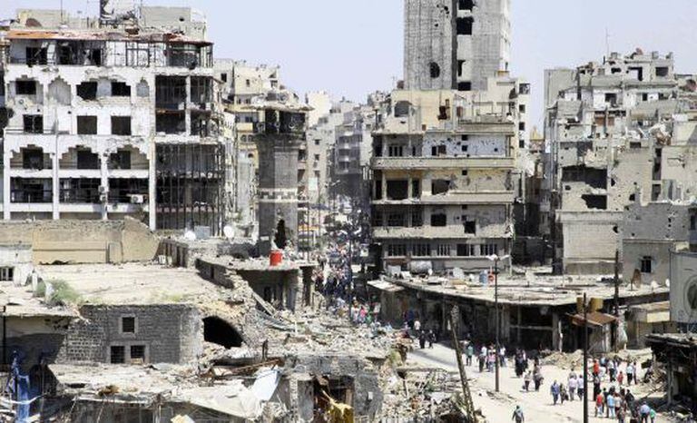 Um grupo de civis chega às ruínas de Homs no sábado passado depois da evacuação dos rebeldes.