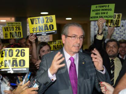 Cunha e cartazes pedindo a derrubada do veto