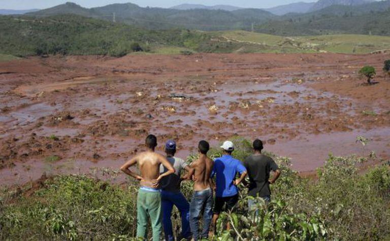 Moradores observam ruas tomadas por lama.