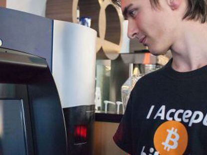 Um cliente observa o primeiro caixa de bitcoins.