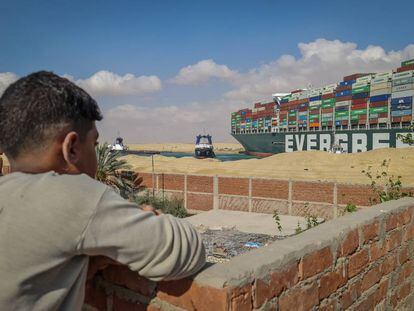 Un niño observa los trabajos de rescate en el canal de Suez.