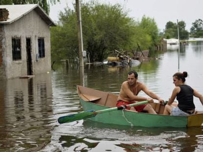 Um casal uruguaio rema um bote nas ruas inundadas de Durazno em 2010.