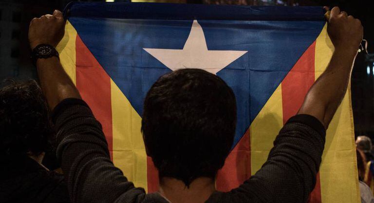 Homem segura bandeira da Catalunha.