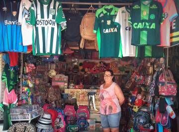 Barraca da Dona Odete vende camisas da Chape e do Atlético Nacional.