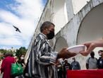 People line up for a free, cooked meal in front of the Carioca Aqueduct, or Arcos da Lapa, in Rio de Janeiro, Brazil, Thursday, April 29, 2021. According to organizers at the volunteer group “Covid Sem Fome,” or Covid Without Hunger, more people are coming to eat amid decreasing supplies, compared to when they started in April 2020. (AP Photo/Bruna Prado)