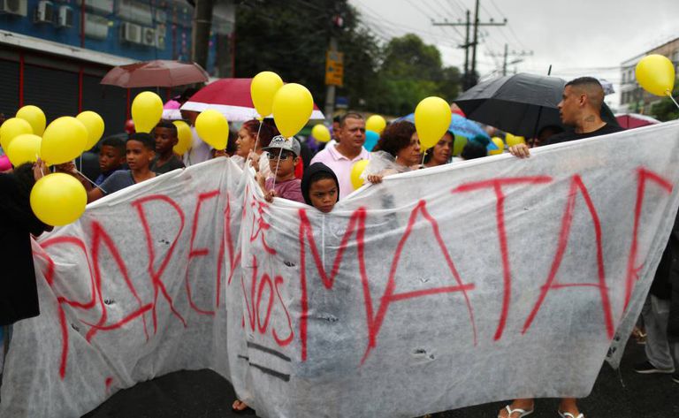 Moradores do Complexo do Alemão protestam durante o cortejo do corpo da menina Ágatha Félix, 8 anos, neste domingo. Na faixa, o protesto: