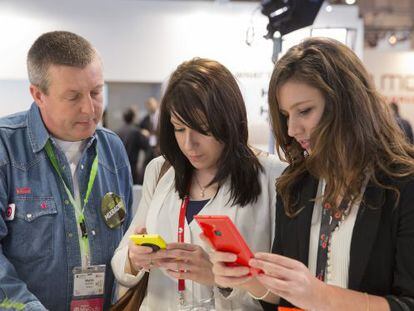 Duas mulheres verificam celulares no Mobile World Congress.