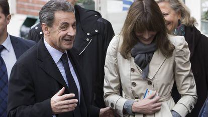 O ex-presidente francês Nicolás Sarkozy e sua esposa, Carla Bruni-Sarkozy, saem de um despacho de voto durante o primeiro turno das eleições primárias