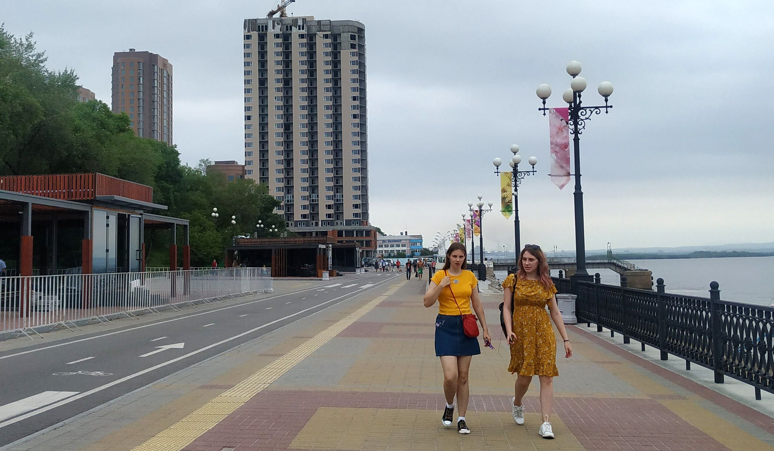 Duas mulheres caminham ao longo do passeio marítimo do rio Amur em Khabarovsk na sexta-feira.