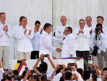 O presidente da Colômbia, Juan Manuel Santos, aperta a mão de Rodrigo Londoño, o Timochenko, líder das FARC, depois da assinatura do acordo final.