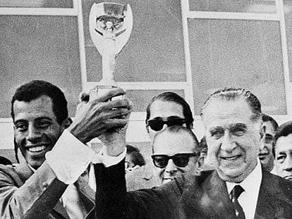 Carlos Alberto levanta a taça de campeão com o ditador Emílio Médici.