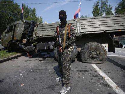 Um membro de um grupo armado pró-russo vigia uma barricada próxima a Donetsk.