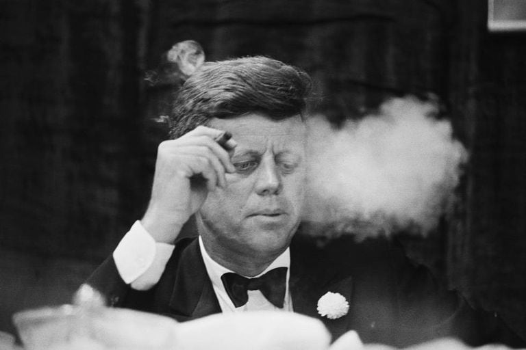 O presidente John F. Kennedy fuma um charuto durante um jantar de arrecadação de fundos do Partido Democrata na Universidade de Boston.